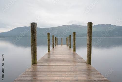 Derwentwater Jetty boat landing with wooden posts and long exposure to produce blurry out of focus water