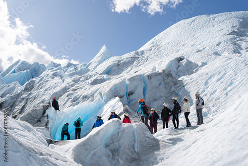 Los turistas y la guía están observando a una persona que está en la parte alta del glaciar Perito Moreno en la Patagonia Argentina.
