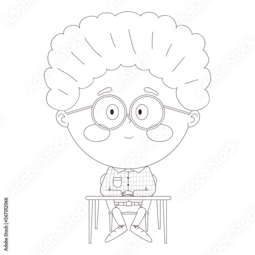 schoolboy sitting at a desk with his hands folded