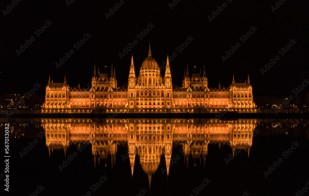 Panoramic of the Parliament of Budapest (Hungary) and its reflection, night photography, from the river.