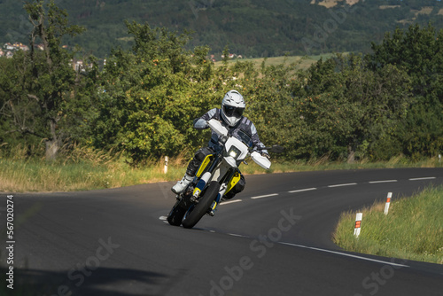 Supermoto motorcycle rider in white helmet on mountain road © Trail Patrol
