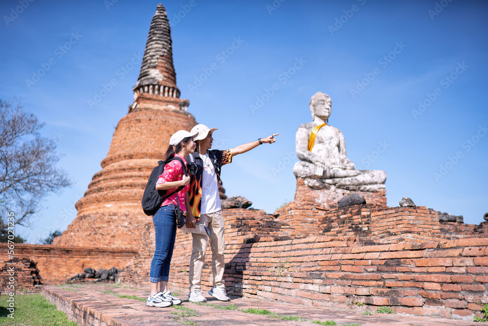 Fototapeta premium Traveler tourist man and women with backpack walking in historical place temple Ayuttaya Thailand