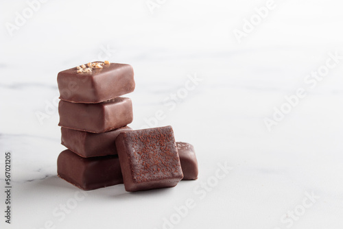 Chocolate bonbons with praline on white marble background photo