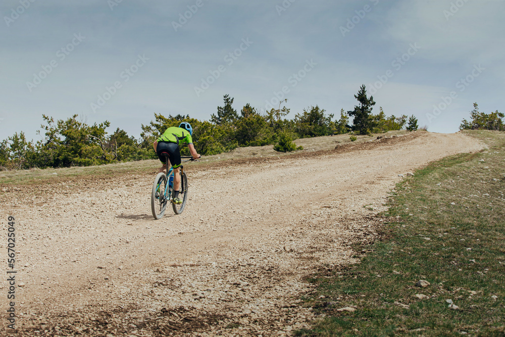 Obraz premium male athlete on mountain bike riding uphill on trail