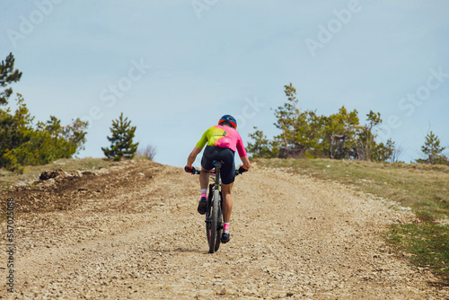 male cyclist riding uphill trail on mountain bike
