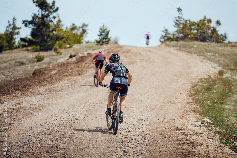 back men athletes on mountainbike riding uphill back men athletes on mountainbike riding uphill