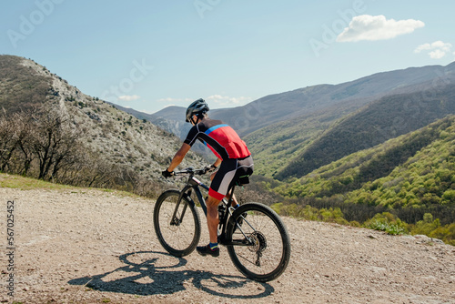 athlete cyclist riding mountain bike on mountain trail