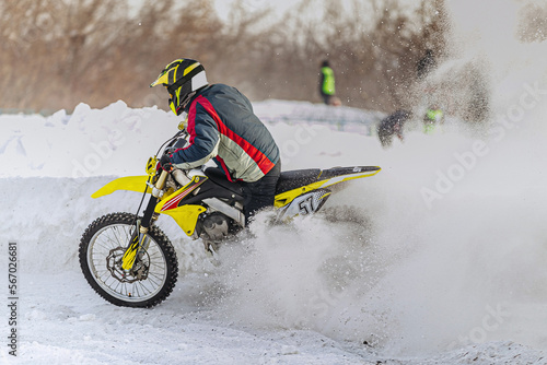 splashes snow and dirt on rear wheel of racing motorcycle