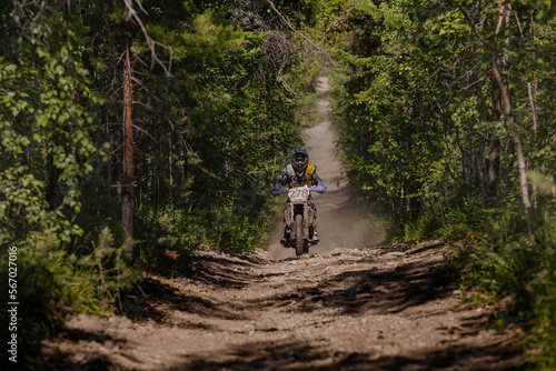 male enduro motorcycle racer riding on forest