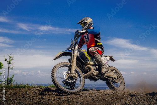 male rider in enduro motorcycle on top mountain