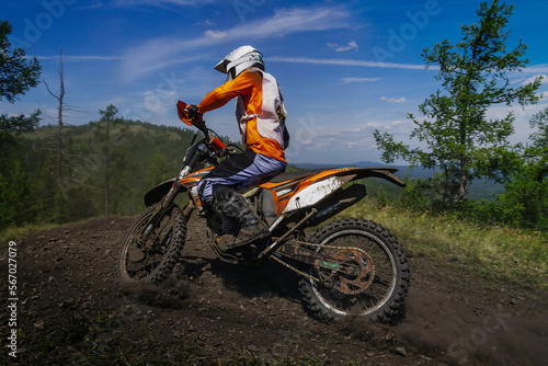 enduro motorcycle racer riding dusty trail