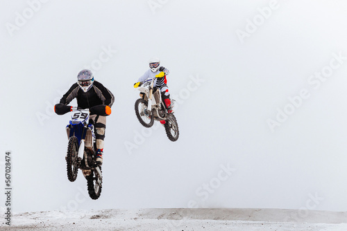two motorcycle racers jump winter enduro race