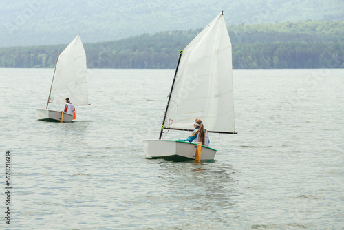 two yachts with young athletes on lake during race