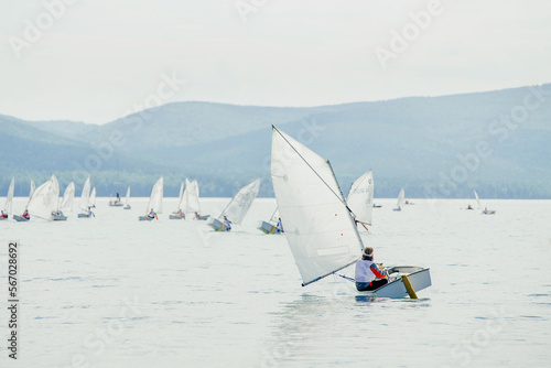 group yachts with young athletes on lake during regatta