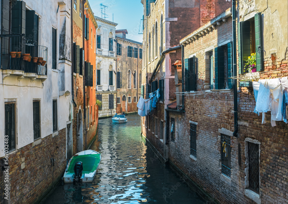 Typical view of Venice with colorful houses reflected in the canal in a sunny day