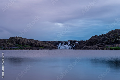 Majestic summer sunrise on Bruarfoss Waterfall. The 'Iceland’s Bluest Waterfall.' Blue water flows over stones. Midnight sun of Iceland. Visit Iceland. Beauty world.