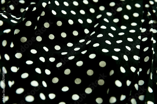 Polka dot patterned black and white fabric textile folded cloths as background