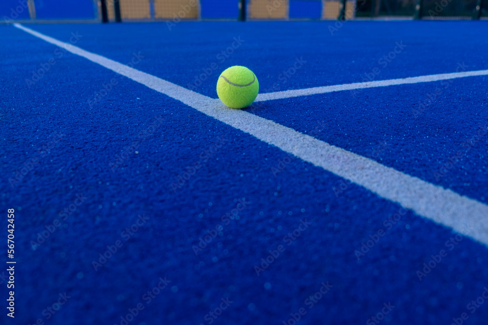 ball on the line of a blue paddle tennis court