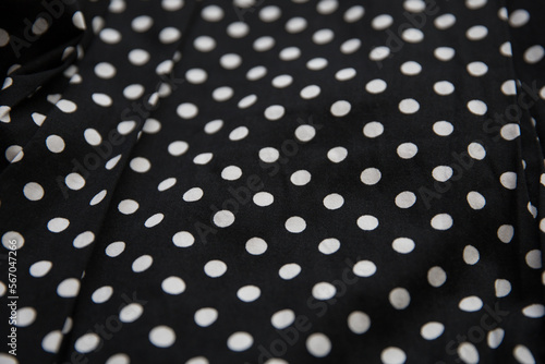 Polka dot patterned black and white fabric textile folded cloths as background