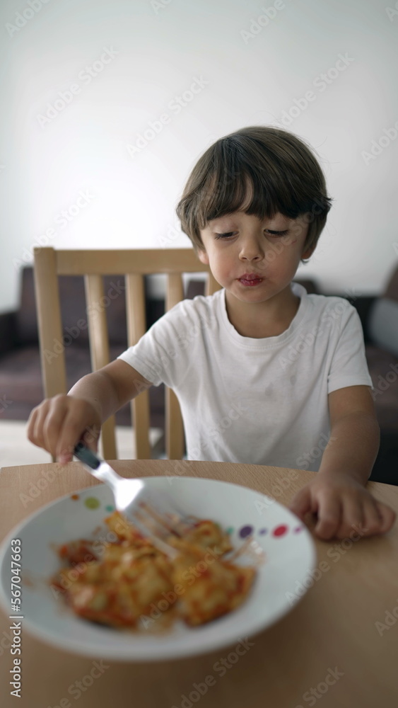Small boy eating pasta on plate. Child eats lunch by himself. Carb food in vertical Video Small boy eating pasta on plate. Child eats lunch by himself. Carb food in vertical Video