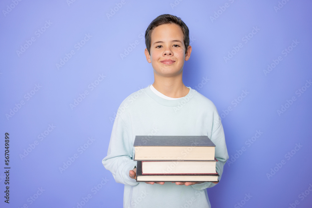 Profile side photo of young boy hold book information materials isolated over purple background Profile side photo of young boy hold book information materials isolated over purple background