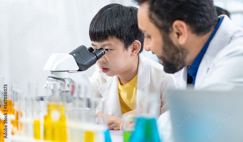 smart young boy enjoys examining chemical laboratory with school teacher assistant, researcher explains a lesson of liquid formula elementary to kid in science academic classroom smart young boy enjoys examining chemical laboratory with school teacher assistant, researcher explains a lesson of liquid formula elementary to kid in science academic classroom
