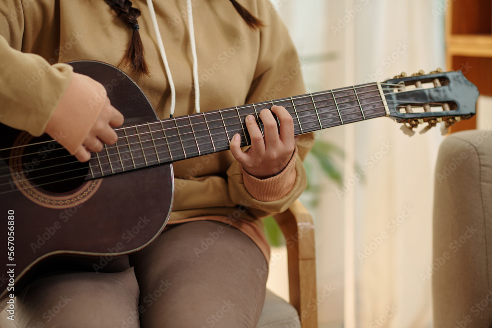 Cropped image of teenage girl playing guitar