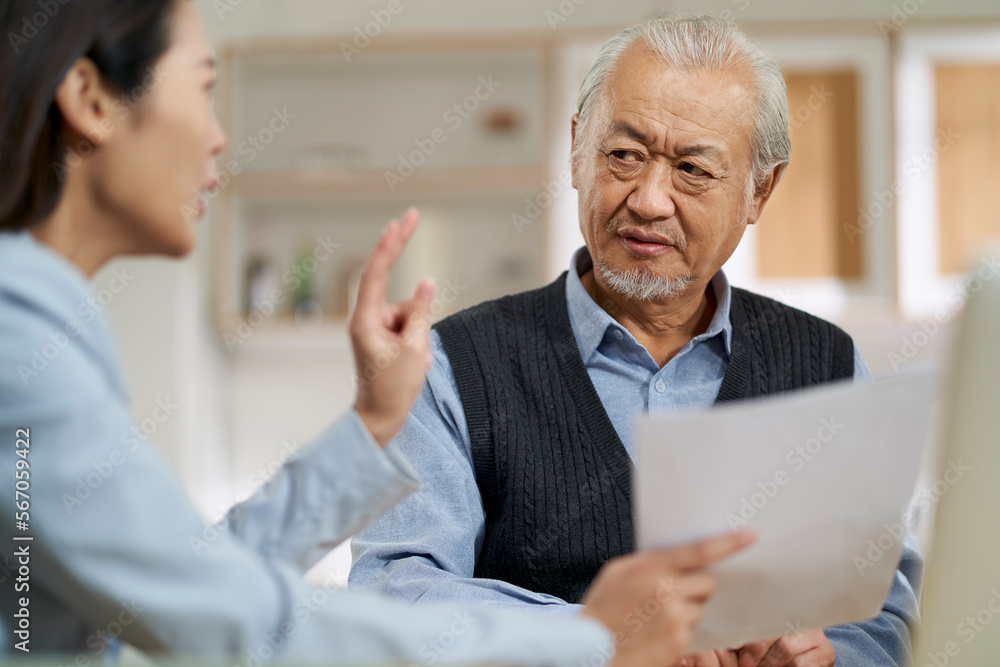 asian old man appears to be unconvinced while listening to a salesperson