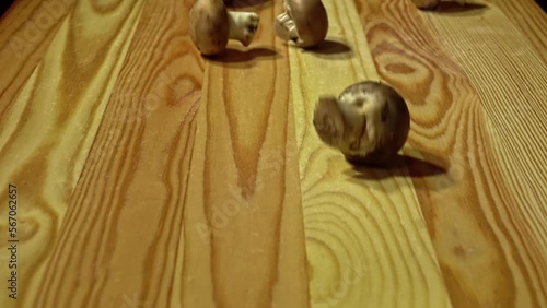 Raw brownmushrooms on wooden chopping board, close-up. Slow motion. photo