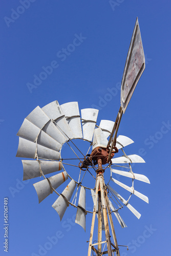Old windmill from the back and sail, from the old cowboy west, with blue sky.