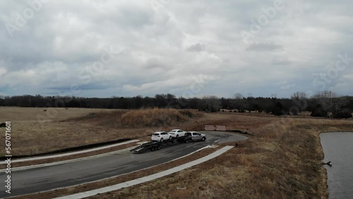 Get an aerial view of a pickup truck towing a carhauler in this review and inspection video. Watch as the semi truck makes a pitstop at a gas station, showcasing its capabilities on the road photo