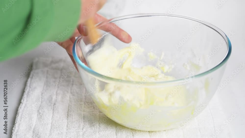 Male cook stirs whipped meringue protein with cooked dough with egg yolk and flour with wooden spatula. High quality 4k footage Male cook stirs whipped meringue protein with cooked dough with egg yolk and flour with wooden spatula. High quality 4k footage