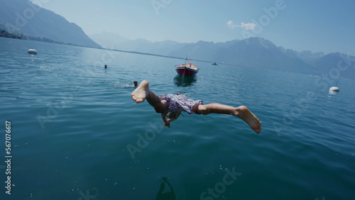 One carefree young boy jumping into water kid enjoys summer vacations
