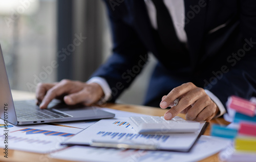 Businessman accountant or financial expert analyze business report graph and finance budget chart in the office. Concept of finance economy, banking business and stock market research.