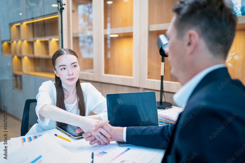 Obraz premium Caucasian businessman checking hands with young attractive businesswoman after finished business deals in office. Business and success concept