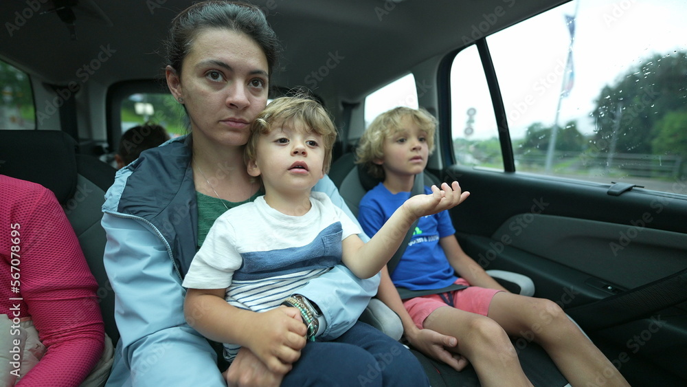 Mother and boy traveling together in the backseat of a car