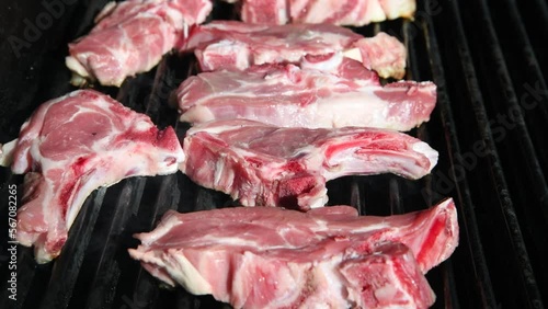 Raw lamb chops on a grill of a gas barbecue, Grilling lamb chops outdoors, Grilled raw Lamb chops, Outdoor BBQ cooking, Gas Barbecue Grill photo