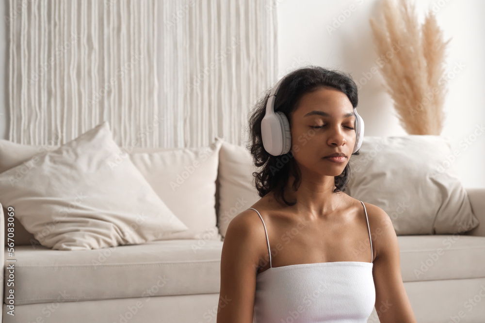 Copy space banner with serene african american woman in headphones meditating. Wellness and zen concept Copy space banner with serene african american woman in headphones meditating. Wellness and zen concept