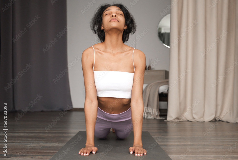 Front view on happy african amercian gifrl prscticing yoga at home. Banner with place for text Front view on happy african amercian gifrl prscticing yoga at home. Banner with place for text