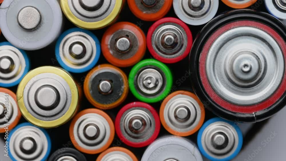 Different batteries close-up rotating on a turntable, top view. Background of colorful batteries.The concept of hazardous waste, disposal of used batteries, ecology. Different batteries close-up rotating on a turntable, top view. Background of colorful batteries.The concept of hazardous waste, disposal of used batteries, ecology.