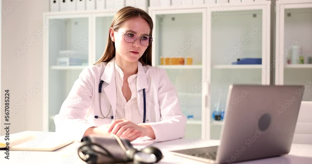 Doctor communicates remotely from laptop with patients or doctors via Internet via video call Doctor communicates remotely from laptop with patients or doctors via Internet via video call