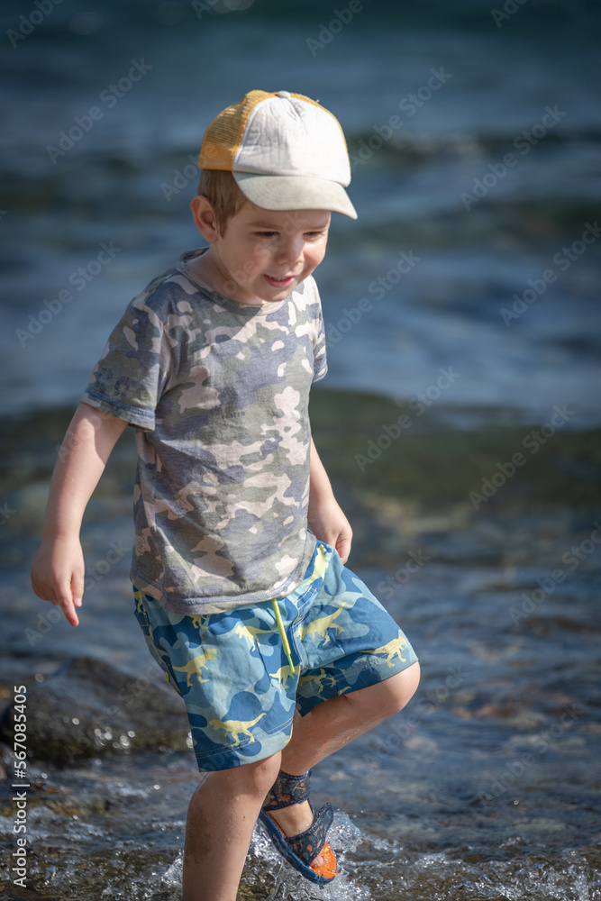 Niño jugando con piedras y agua a orillas de un lago Stock Photo ...