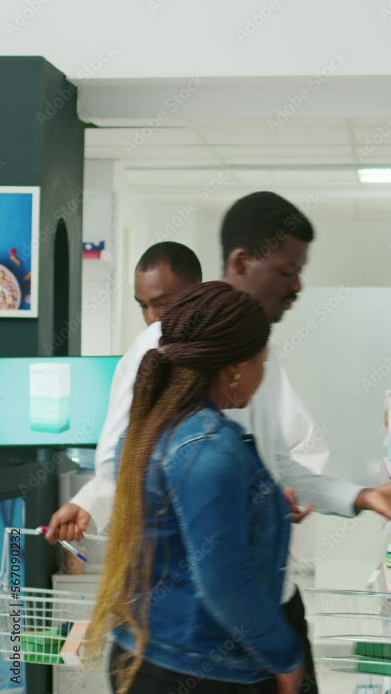 Vertical video: Male specialist putting stock of medicaments and drugs on pharmacy shelves, putting boxes of pills and vitamins to help clients. Young adult working with pharmaceutical products Vertical video: Male specialist putting stock of medicaments and drugs on pharmacy shelves, putting boxes of pills and vitamins to help clients. Young adult working with pharmaceutical products