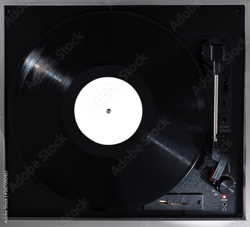 A turntable with a black vinyl that has an empty white label