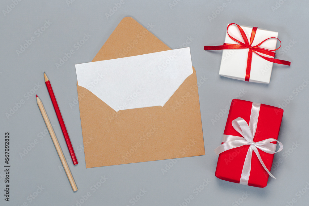 Above view flat lay composition of craft paper envelope and blank white postcard, isolated on grey background Above view flat lay composition of craft paper envelope and blank white postcard, isolated on grey background