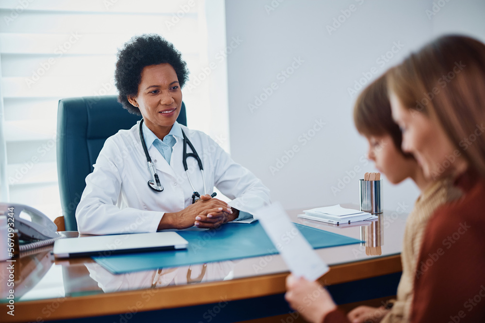 Black female pediatrician having medical appointment with mother and child at clinic. Black female pediatrician having medical appointment with mother and child at clinic.