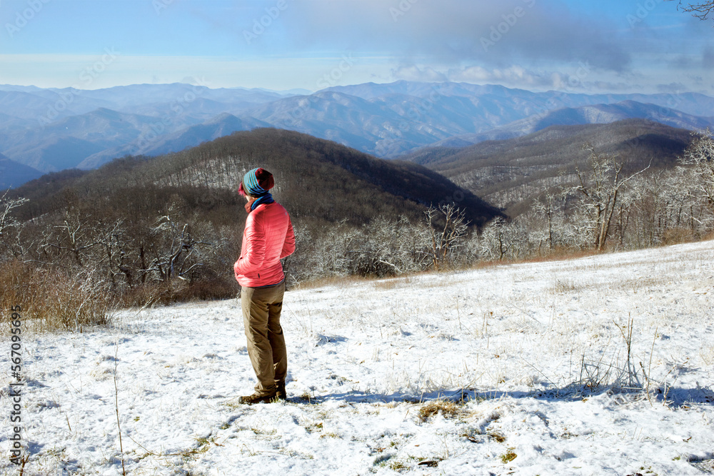 A hiker takes in a view along a ridge line. A hiker takes in a view along a ridge line.