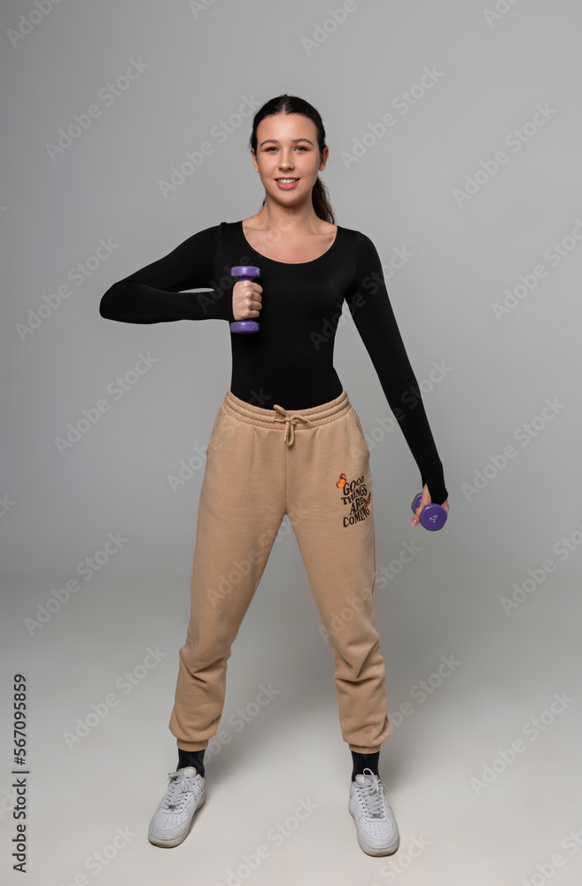 Young fitness model trains with dumbbells Young fitness model trains with dumbbells