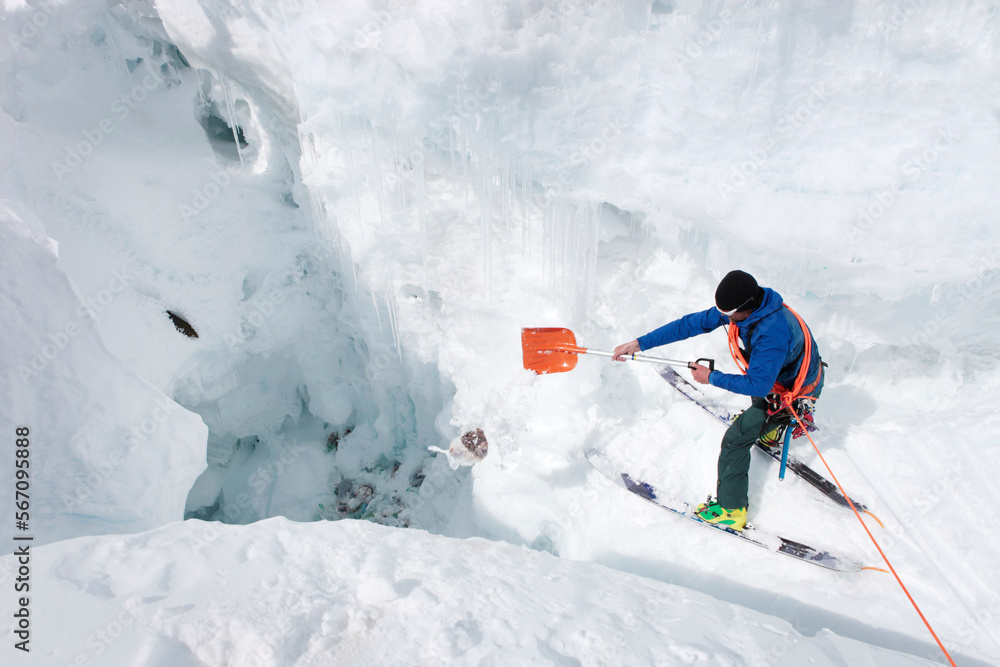 A mountain ranger is shoveling a bag with human waste in a crevasse at ...