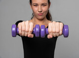 Young fitness model trains with dumbbells